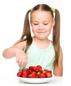 快乐的小女孩在吃草莓