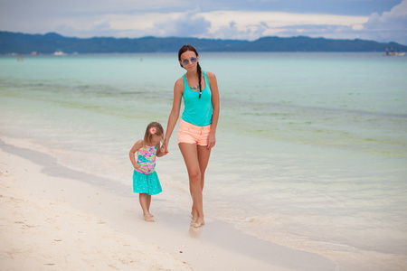 年轻的母亲和她的小女儿享受海滩度假