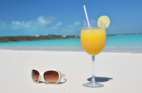 桔汁和海滩上的太阳镜。埃克苏马巴哈马