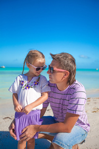 快乐的父亲和他可爱的小女儿一起在沙滩上