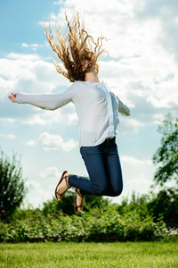 绿色的草地上跳跃的女人