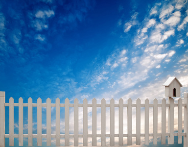 白色的篱笆与鸟房子和蓝蓝的天空