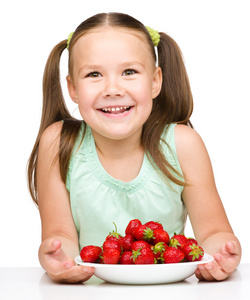性格开朗的小女孩在吃草莓