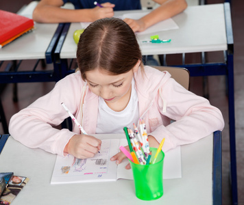 女学生在教室里的桌子在绘制