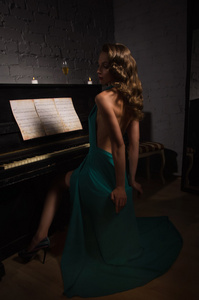 弹钢琴的晚装裙的美丽女人图片