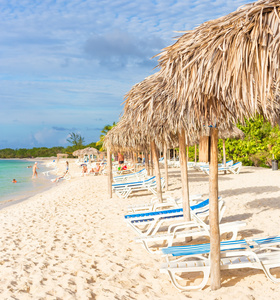 在古巴的热带海滩在茅草遮阳伞