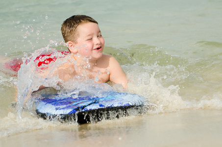 儿童在 bodyboard 在海滩上冲浪