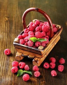 成熟甜树莓在木制背景上篮