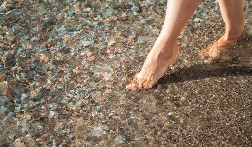 女人的腿附近海边散步图片