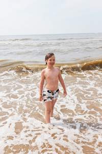在大海的波浪中海滩很开心的孩子男孩