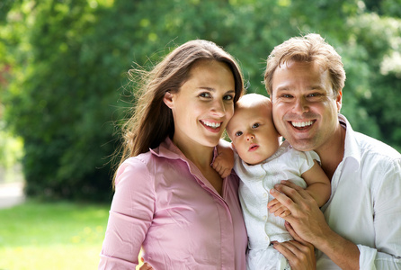 快乐年轻白人家庭抱着婴儿的图片