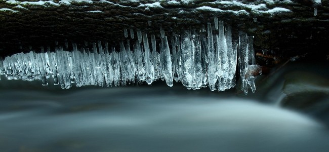 晚冬查看到冰柱和冰冷的巨石到流