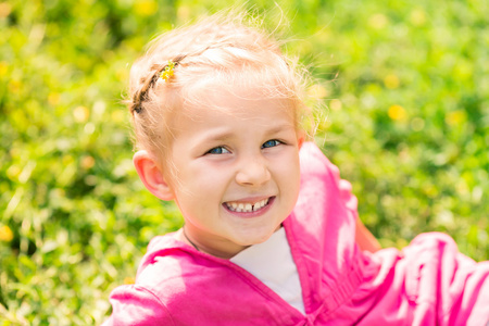 可爱微笑的小女孩在草地上