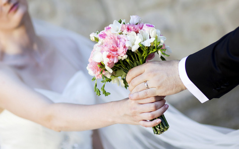 手和婚礼的花束上的戒指