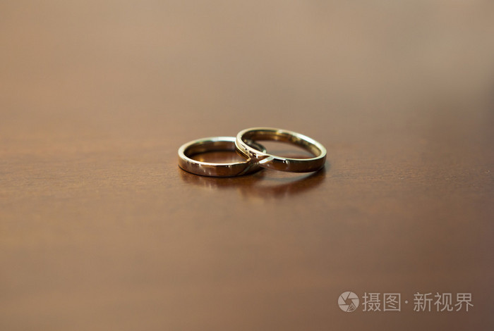 木桌上的两个金结婚戒指