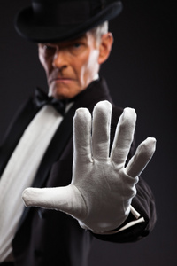 魔术师使神秘的手势。戴着帽子和黑色西装