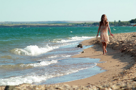 一个微笑的小女孩，在沙滩上的肖像