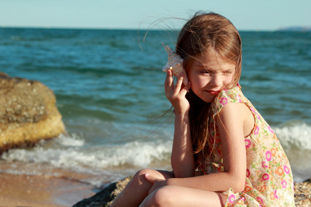 一个快乐的年轻女孩，在一个夏天的肖像的连衣裙贝壳