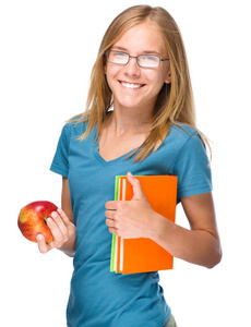 年轻的学生女孩拿着书和苹果