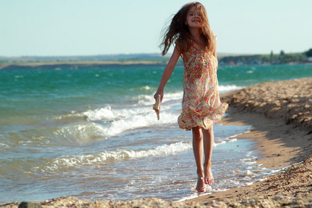 一个微笑的小女孩，在沙滩上的肖像