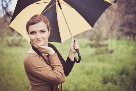 在秋天公园雨伞的女孩
