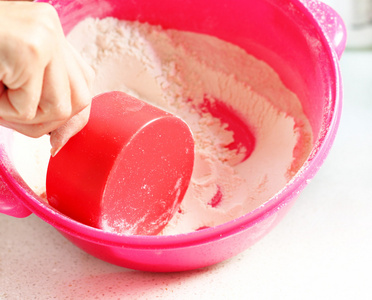 在一个粉色的塑料碗面粉