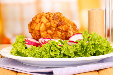 基辅鸡配生菜沙拉，木桌上，在明亮的背景上的烤面包片上