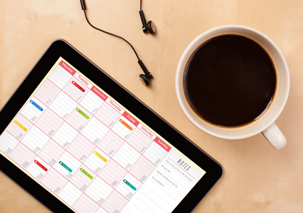 平板电脑与一杯咖啡在 d 上的屏幕上显示的日历
