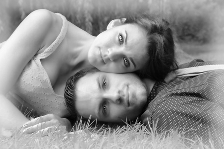躺在草地上一对年轻夫妇的黑色和白色版本 wi