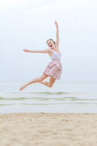 海边上跳跃的年轻快乐的女人
