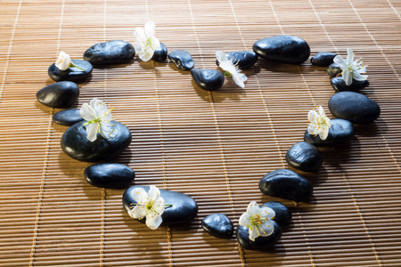 心与黑石头和竹凉席上的花