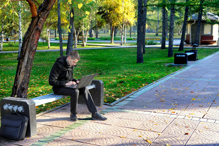 在公园的笔记本电脑的男人