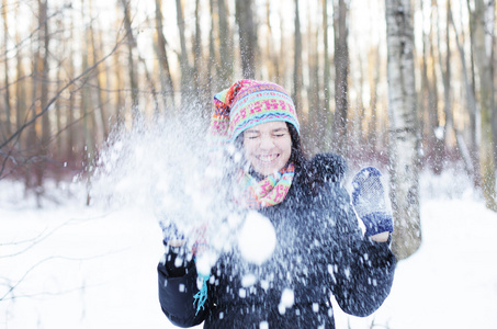 女人在冬天公园，调皮地吹雪