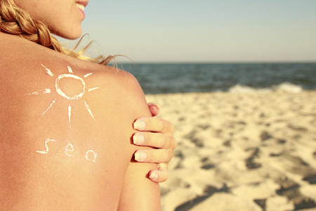 太阳霜在海滩上的女性背上的
