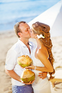 婚礼上海滩情侣接吻控股椰子鸡尾酒