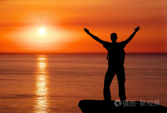 男人在山在夕阳的剪影米的山顶上的人