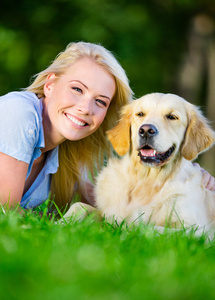 关门的金毛猎犬在草地上的女人