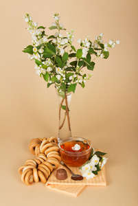 喝杯茶 面包 巧克力和米色背景上花瓶里的花