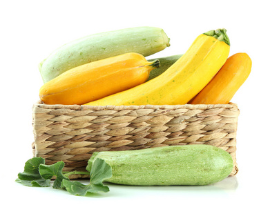 原料黄色和绿色西葫芦在柳条箱，隔离在白色