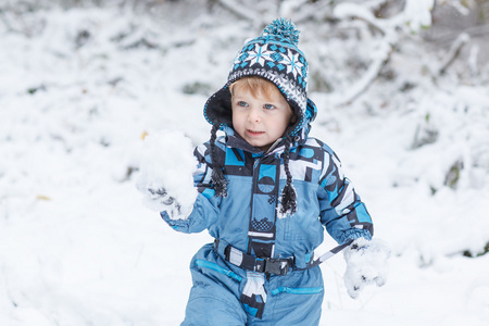 可爱的小孩男孩在冬季一天玩雪