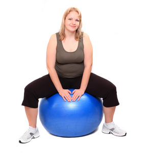 拍摄的一个超重的年轻女子，与上一个白色的背景的蓝色球