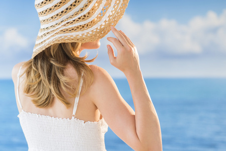 女人对海戴太阳帽的后视图