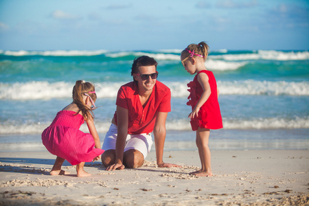 年轻的父亲和他可爱的小女儿，在沙滩上玩