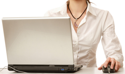 一个年轻的女子坐在一台笔记本电脑