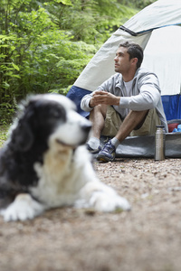人与狗坐在帐篷里