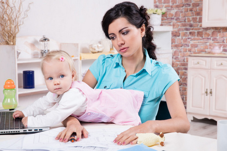 商务笔记本电脑和她的宝贝女儿的女人