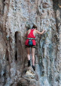 女人爬上岩石路线夏天 莱利海滩，甲米临