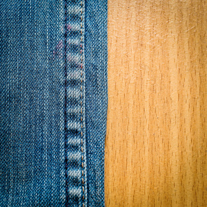 木材纹理背景上的蓝色牛仔裤
