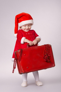 小小快乐的女孩，带着圣诞小提箱