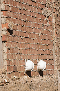 墙上挂着的两个建筑工人头盔